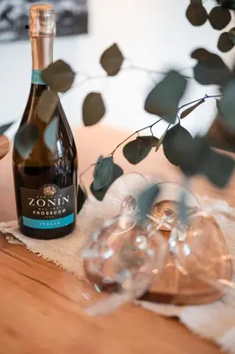a bottle of wine and glasses on a table at Promenaden Lounge in Merano