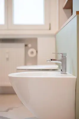 a white sink with a faucet in a bathroom at Promenaden Lounge in Merano