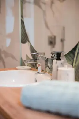 a bathroom sink with a faucet and a mirror at Promenaden Lounge in Merano
