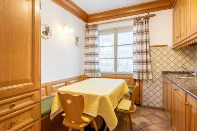a small kitchen with a table and a window at OLIMPIA LODGE in Cortina dʼAmpezzo