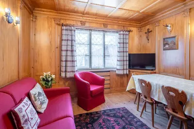 a living room with a table and a couch and a tv at OLIMPIA LODGE in Cortina dʼAmpezzo