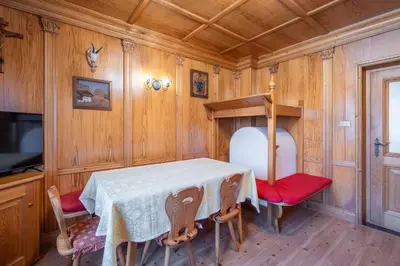a dining room with a table and red chairs at OLIMPIA LODGE in Cortina dʼAmpezzo