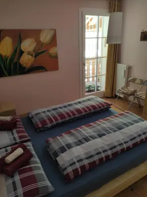 two beds in a room with a painting on the wall at Appartamento Monte Civetta in Pieve di Livinallongo