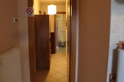 a hallway with a door to a bathroom with a toilet at Appartamento Monte Civetta in Pieve di Livinallongo