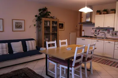 a kitchen and dining room with a wooden table and chairs at Appartamento Monte Civetta in Pieve di Livinallongo