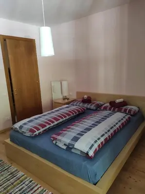 a bedroom with a bed with a blue comforter at Appartamento Monte Civetta in Pieve di Livinallongo