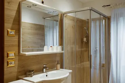 a bathroom with a sink and a shower with a mirror at Donatella&Thomas in Siror