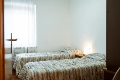 three beds in a hotel room with a window at Donatella&Thomas in Siror