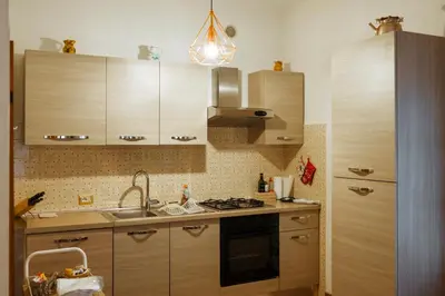 a kitchen with wooden cabinets and a sink and a stove at Donatella&Thomas in Siror