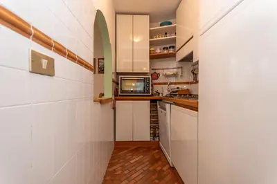 a kitchen with white cabinets and a microwave at Appartamento Green House in Moena