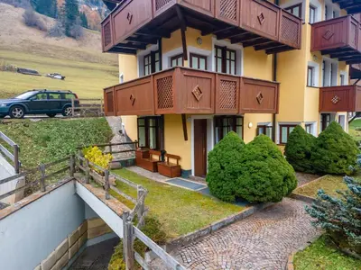 a building with a car parked in front of it at Appartamento Green House in Moena