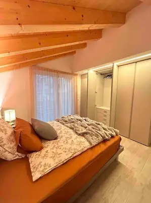 a bedroom with a bed with pillows and a ladder at Agordo Col di Foglia in Agordo