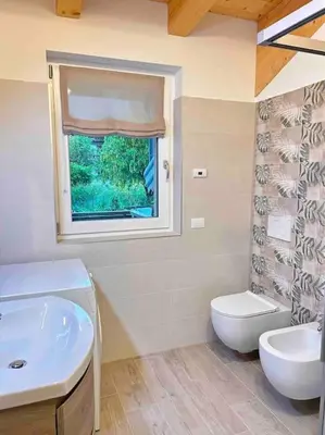 a bathroom with a sink and a toilet and a window at Agordo Col di Foglia in Agordo