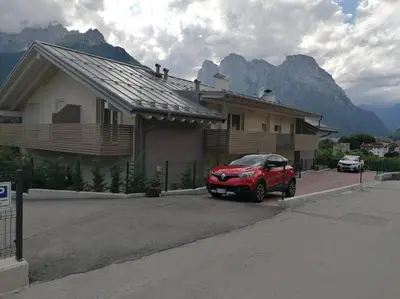 a red car parked in front of a house at Agordo Col di Foglia in Agordo