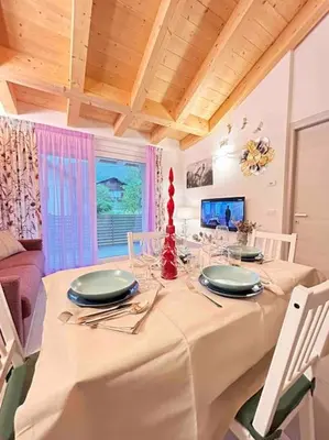 a dining room with a table with plates and glasses at Agordo Col di Foglia in Agordo