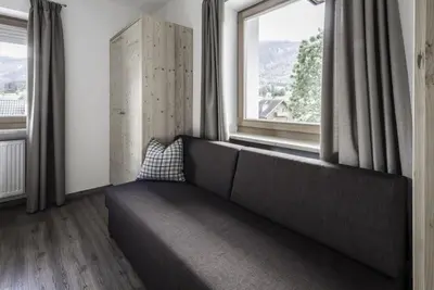 a couch in a room with a large window at Haus Spielbichl in San Lorenzo di Sebato