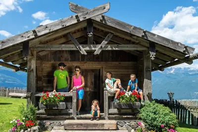 a group of people sitting in a small cabin at Haus Spielbichl in San Lorenzo di Sebato