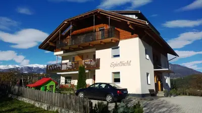 a house with a car parked in front of it at Haus Spielbichl in San Lorenzo di Sebato