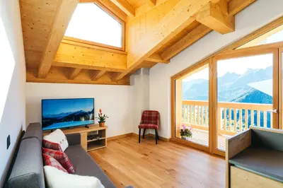 a living room with a couch and a television at Chalet M in Val di Zoldo