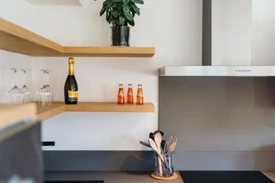 a kitchen with a bottle of wine and wine glasses at Chalet M in Val di Zoldo