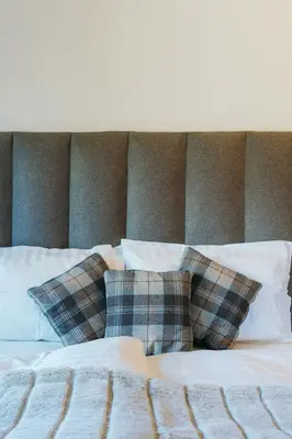 a bed with plaid pillows on top of it at Chalet M in Val di Zoldo