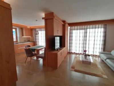 a living room with a couch and a table with a television at Casa Mariella - Apartment with garden in Tesero