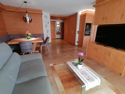 a living room with a couch and a table at Casa Mariella - Apartment with garden in Tesero