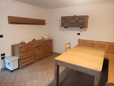 a kitchen with a wooden table and a wooden cabinet at Appartamento Robert Arabba in Livinallongo del Col di Lana