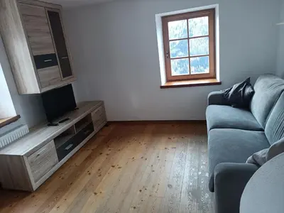 a living room with a couch and a flat screen tv at Appartamento Robert Arabba in Livinallongo del Col di Lana