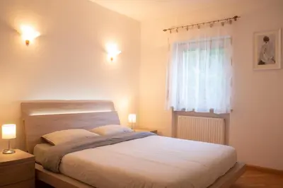 a bedroom with a large bed and a window at Strategic apartment - near Bolzano in Prato allʼIsarco