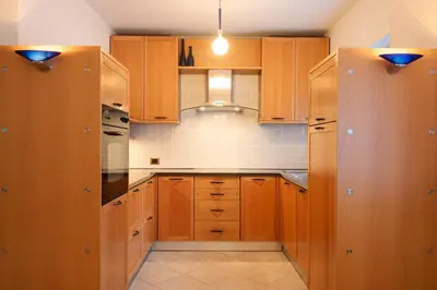 a kitchen with wooden cabinets and a stove top oven at Strategic apartment - near Bolzano in Prato allʼIsarco