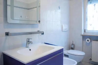 a white bathroom with a sink and a toilet at Strategic apartment - near Bolzano in Prato allʼIsarco