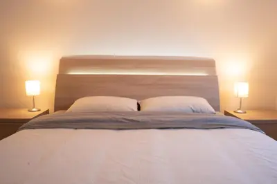 a bed with two white pillows and two lamps at Strategic apartment - near Bolzano in Prato allʼIsarco