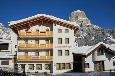 a hotel in the mountains with snow on the ground at Garni Reutlingen in Colfosco