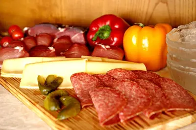 a plate of meats and vegetables on a table at Garni Reutlingen in Colfosco
