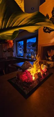 a fire in a living room with a fireplace at Garni Reutlingen in Colfosco