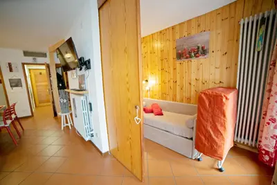 a small room with a bed and a kitchen at Le Nasse in San Martino di Castrozza