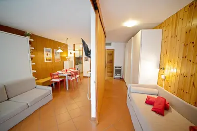 a living room with a couch and a dining room at Le Nasse in San Martino di Castrozza