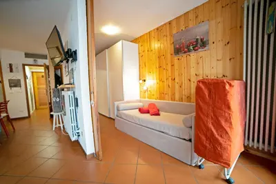 a living room with a white couch and wooden walls at Le Nasse in San Martino di Castrozza