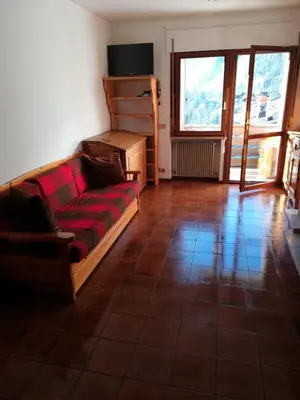 a living room with a couch and a large window at Ciasa de Carla in Masarè
