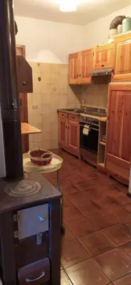 a kitchen with wooden cabinets and a stove top oven at Ciasa de Carla in Masarè