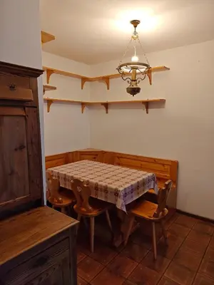 a dining room with a table and chairs and a chandelier at Ciasa de Carla in Masarè