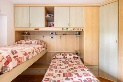 a bedroom with a bed and cabinets and a shelf at Casa vacanze in Val di Non in Romeno