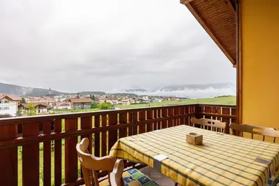 a table and chairs on a balcony with a view at Casa vacanze in Val di Non in Romeno