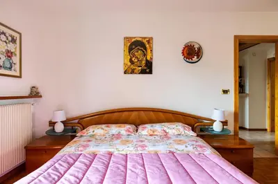 a bedroom with a large bed with a pink blanket at Casa vacanze in Val di Non in Romeno