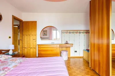 a bedroom with a bed and a desk and a sink at Casa vacanze in Val di Non in Romeno