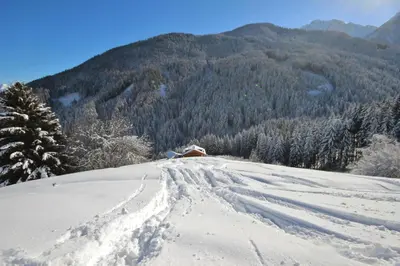 a snow covered hill with a house in the distance at Residenz Erschbaum in Valdaora
