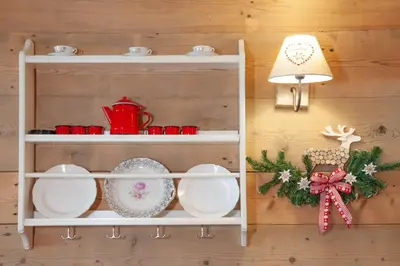 a white shelf with dishes and a lamp on a wall at Casa Fiore CIPAT 22038 in Canale San Bovo