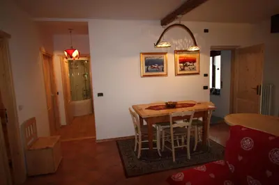 a kitchen with a table and chairs in a room at Casa Fiore CIPAT 22038 in Canale San Bovo