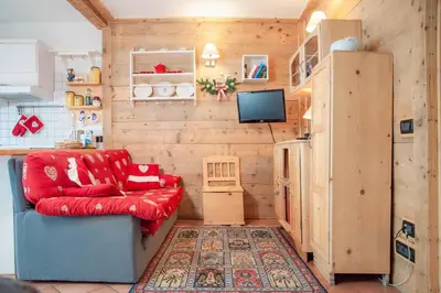 a living room with a red couch and a refrigerator at Casa Fiore CIPAT 22038 in Canale San Bovo